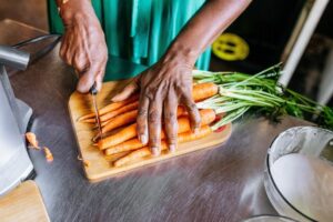 Person cutting up carrots in a kitchen