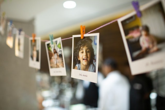 Photos clipped to a line strung across a room