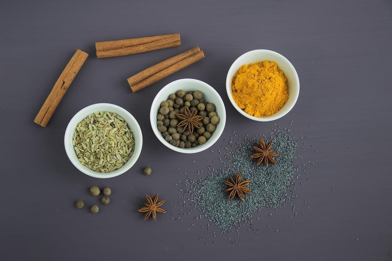 Pile of aromatic Indian spices like fennel seeds, star anise and turmeric.