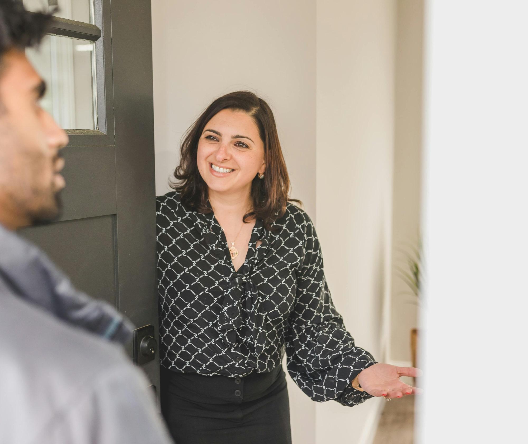 Female estate agent welcoming a buyer into a residential property