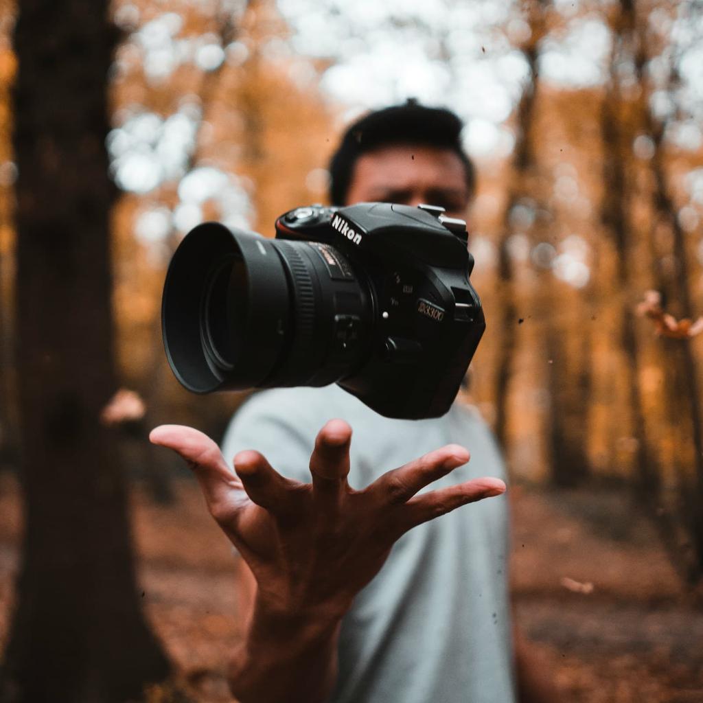 Man tossing a Nikon camera in the air