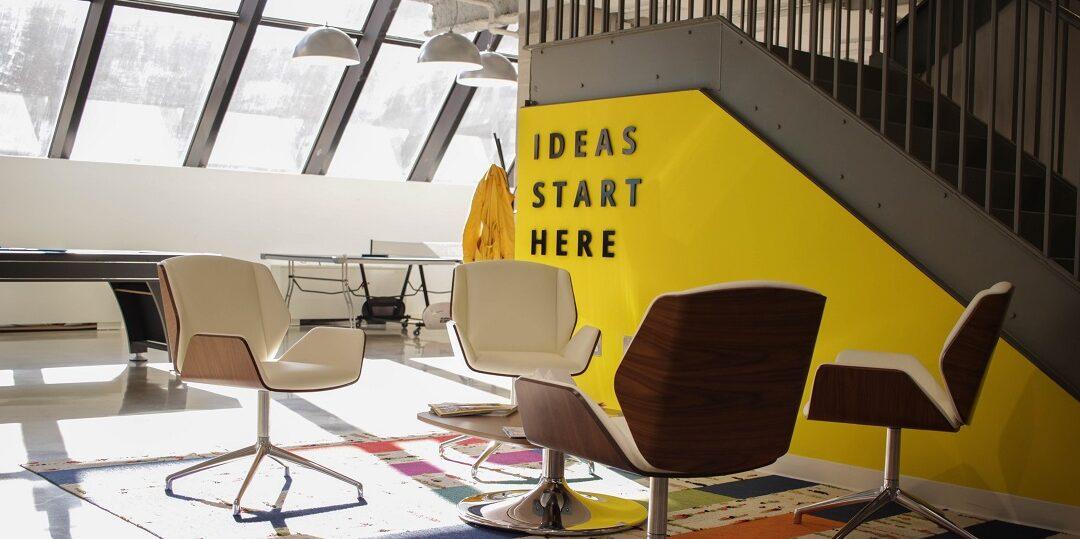 Lounge with chairs and the words &quot;Ideas start here&quot; on a yellow wall