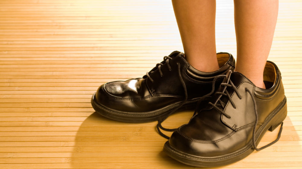 kid in dad's shoes