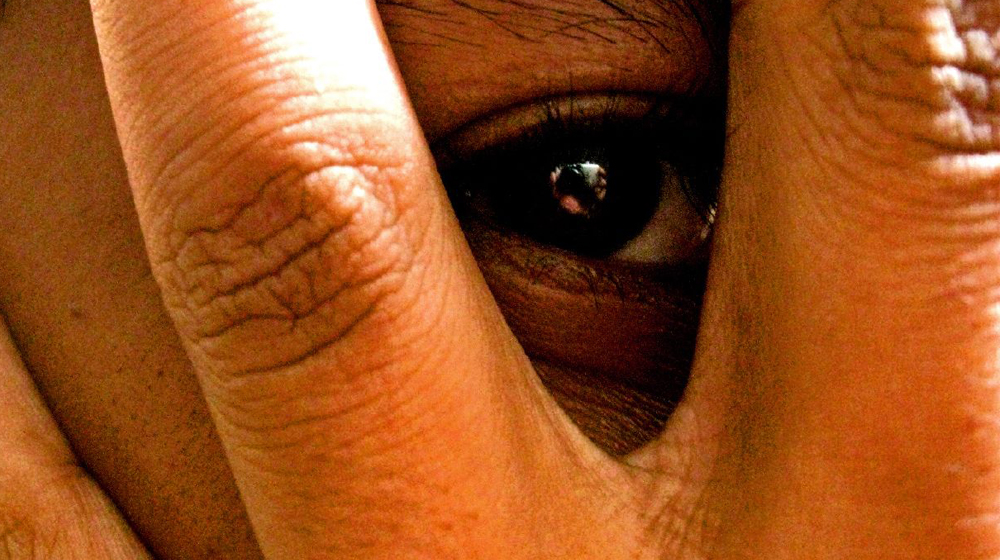 Close up of person covering face to illustrate that a business blog shouldn't be all about you