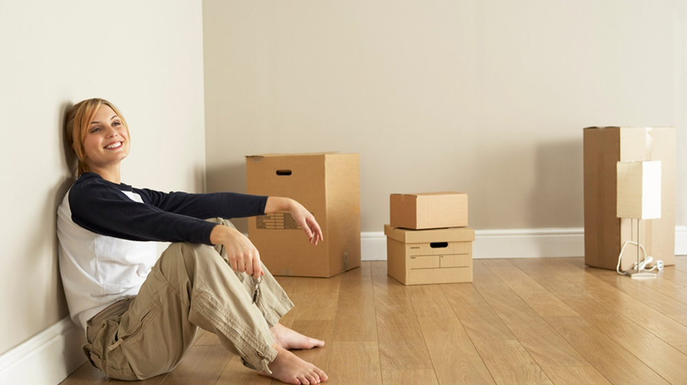 happy new homeowner sitting with boxes to represent custom domain