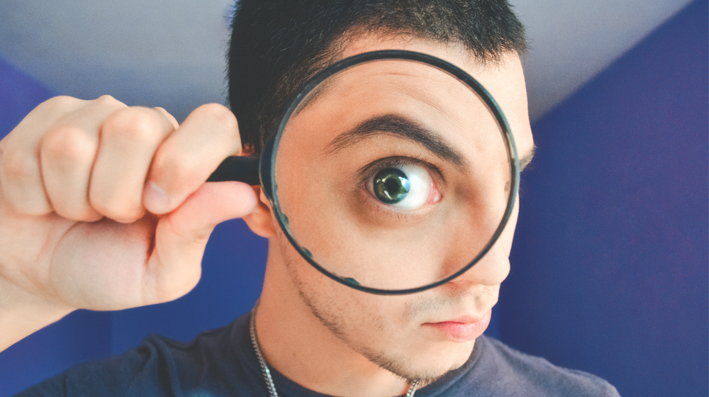 Big eye through magnifying glass to represent importance of website review