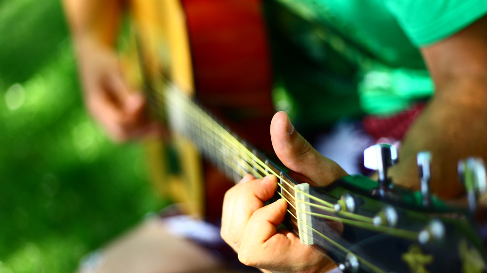 Close-up on guitar to represent turning music hobby into a business
