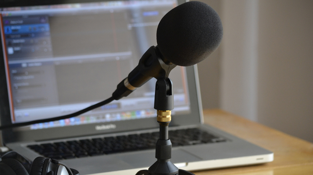 microphone in front of computer to represent podcast on wordpress