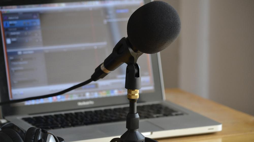 microphone in front of computer to represent podcast on wordpress