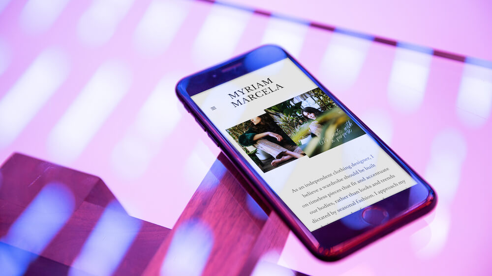 website on mobile phone with pink lighting