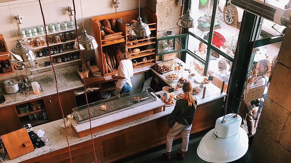 Woman Working At Bakery With Customers Waiting