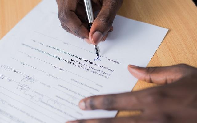 Person Signing Contract Demonstrating How To Get A Business Line Of Credit