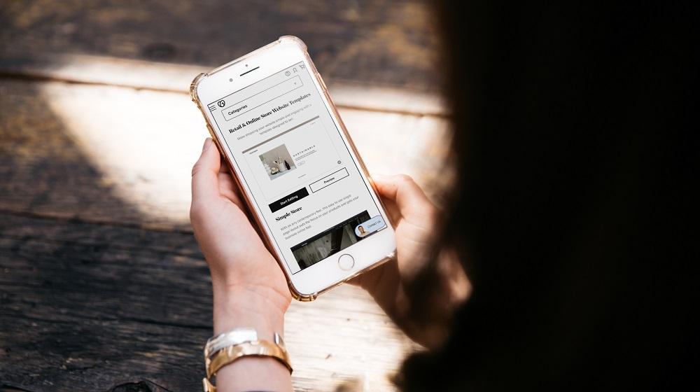 Woman Looking At Mobile Site Template Options