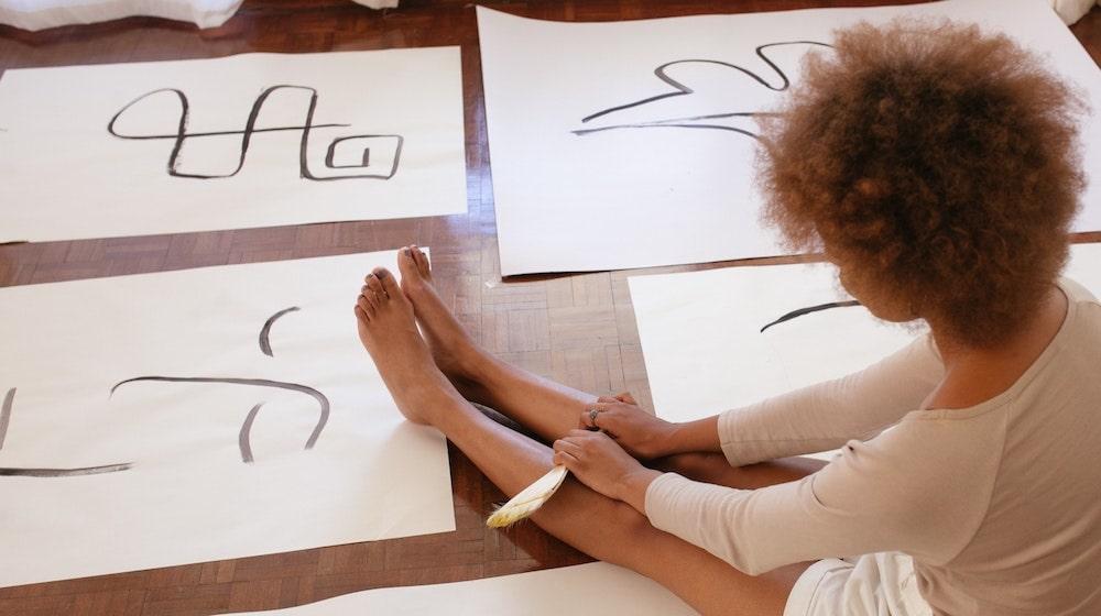 Woman sitting on floor with her artwork
