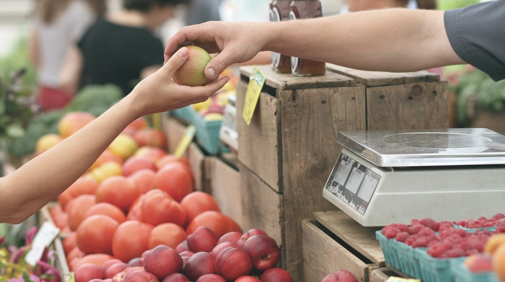 Vendor Handing Fruit To Customer