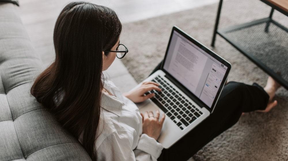 Woman Working On Laptop Sitting on Floor