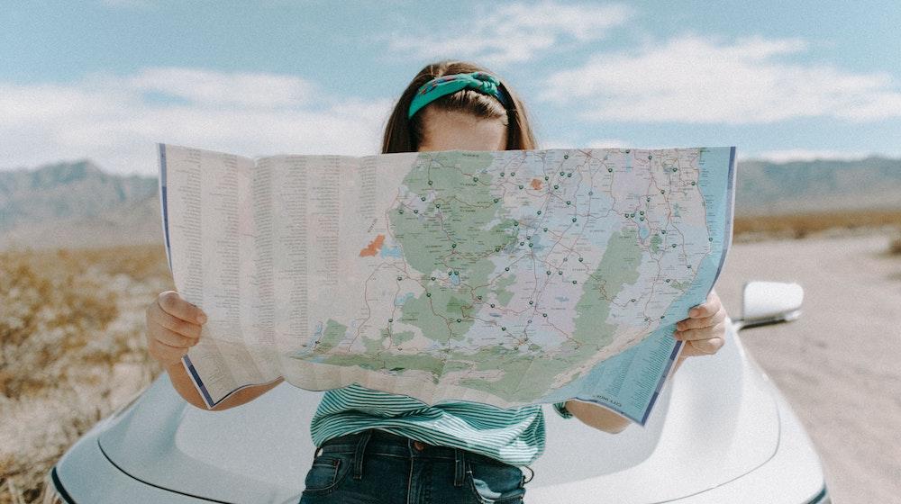 Girl reading map in desert