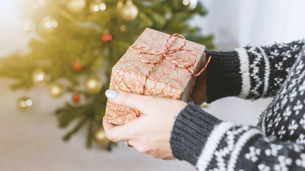 Create A Holiday Gift Guide Woman Holding Package