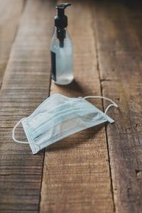 Mask and hand sanitizer on wood table