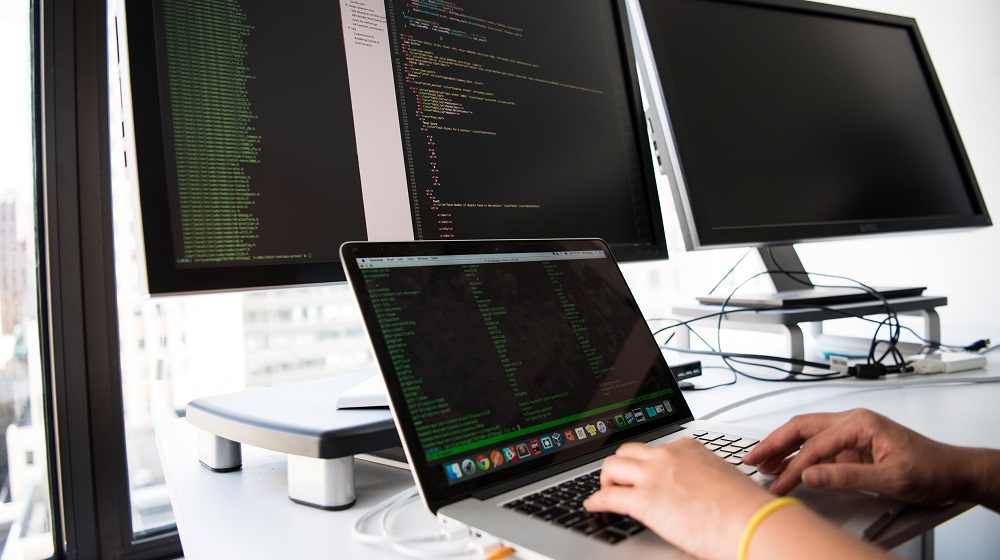 Person working at computer with multiple monitors