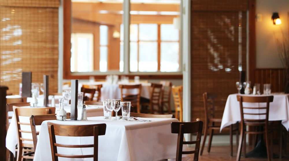 Restaurant with tables set with tablecloth and glasses