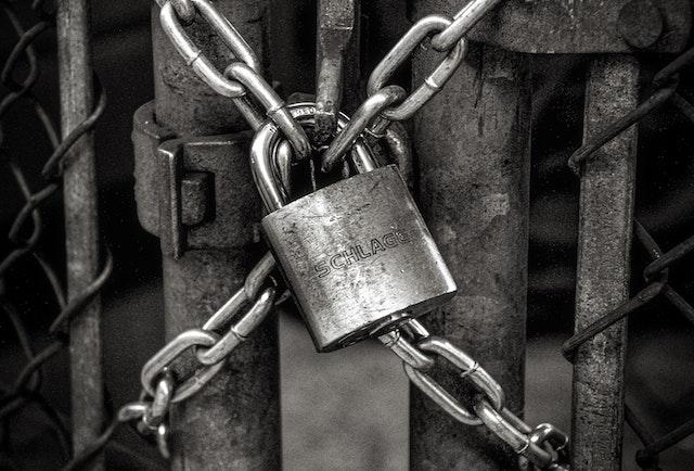 black and white lock on chainlink fence