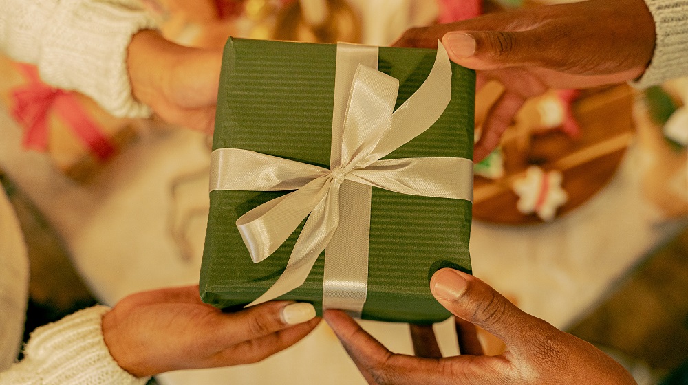Two people exchanging a wrapped gift