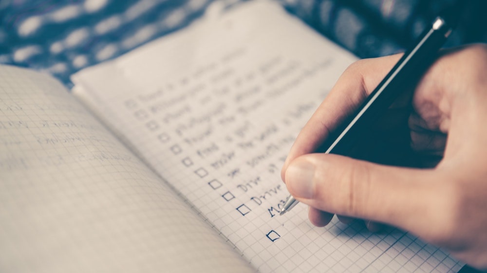 Person writing a checklist