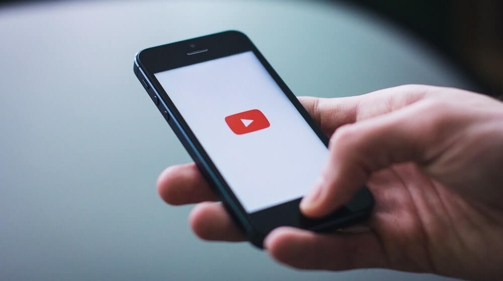 Person opening YouTube on iPhone