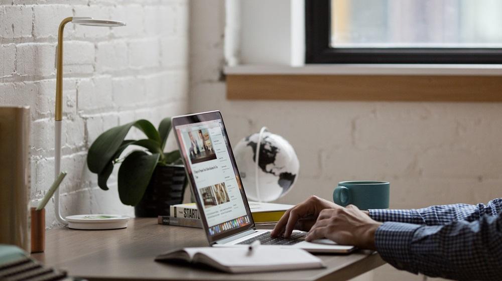 Man working at computer desk on laptop