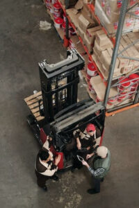 People on forklift in factory]