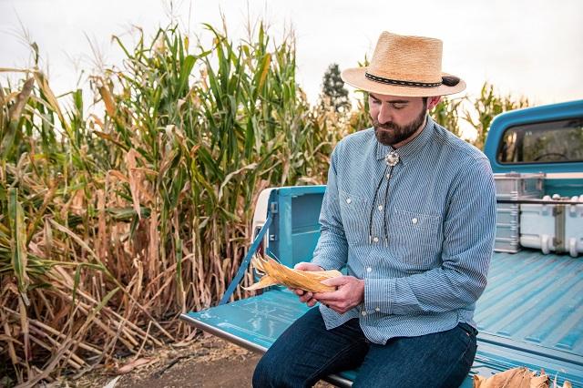 Evan Rocheford inspecting Orange Corn