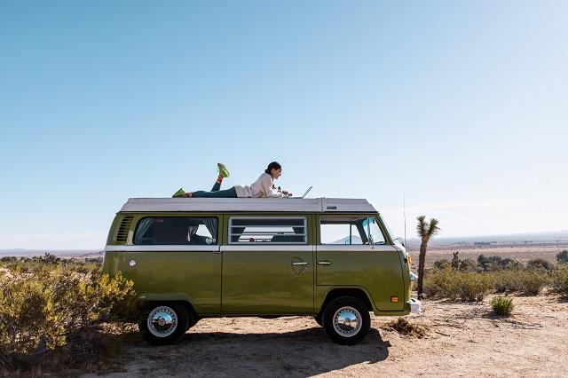 Lizzy VanPatten on a green camper van in the desert