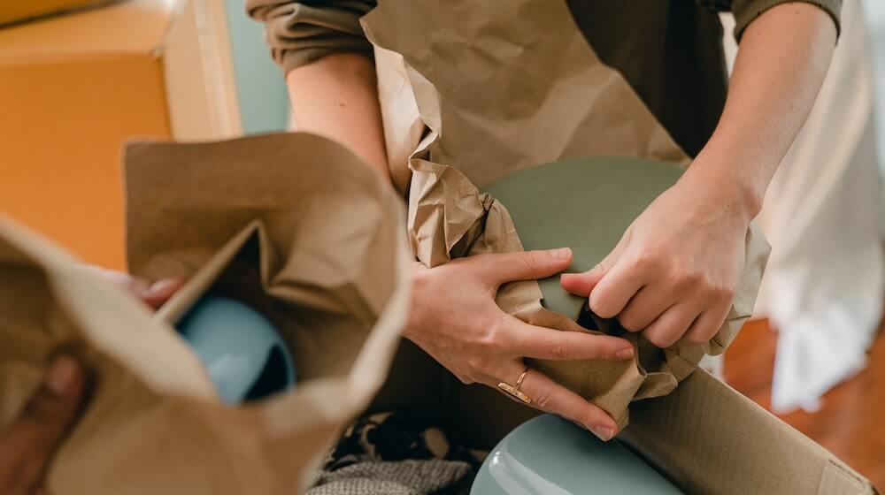 person packing up bowls for moving
