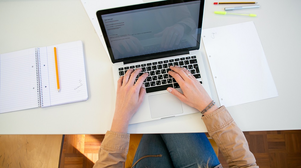 Person using laptop on computer table