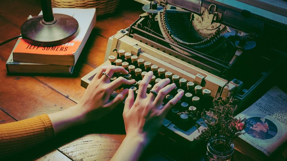 Person typing on old typewriter