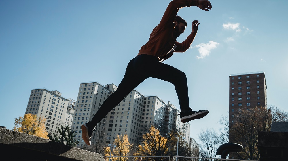 Man jumping from concrete ledge