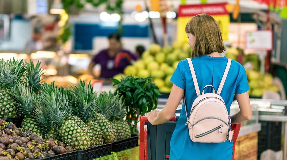 Woman in grocery store reviewing her options