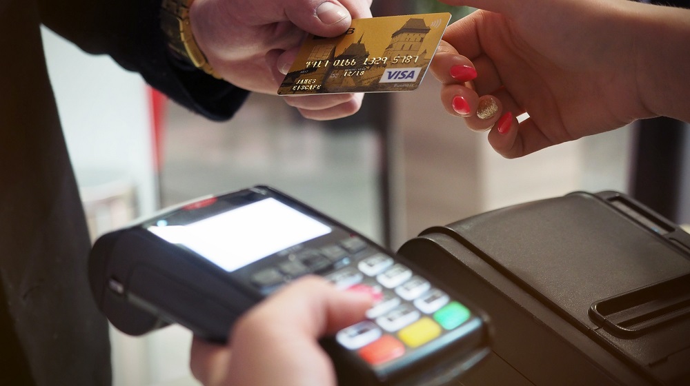 Man handing cashier credit card