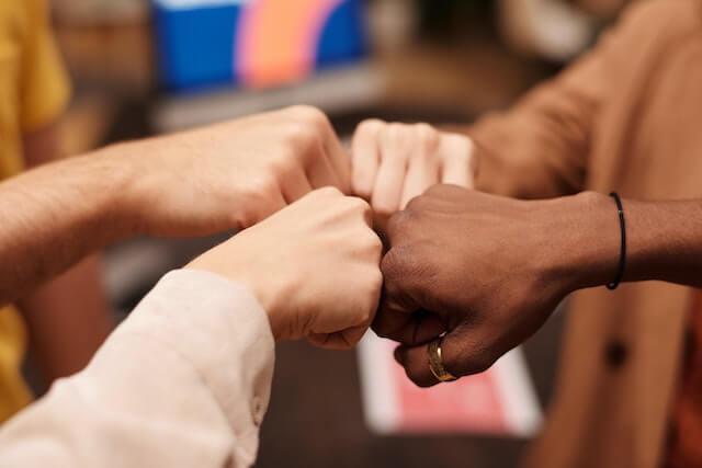 four people doing a fist bump