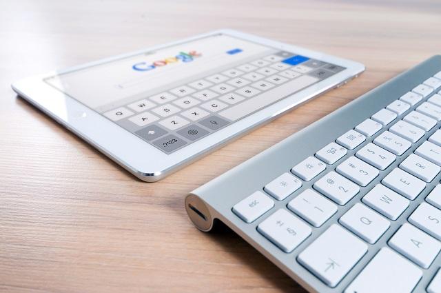 Tablet resting in front of a keyboard with a search page open