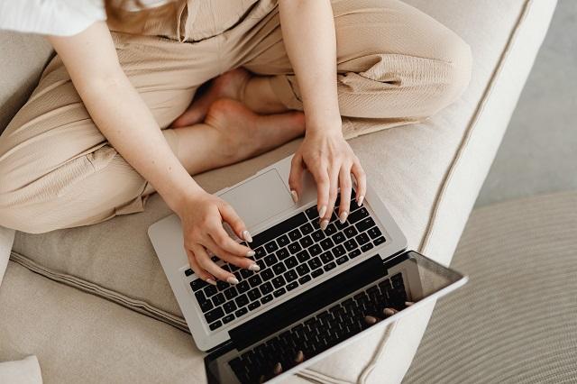 Person using laptop on a sofa]