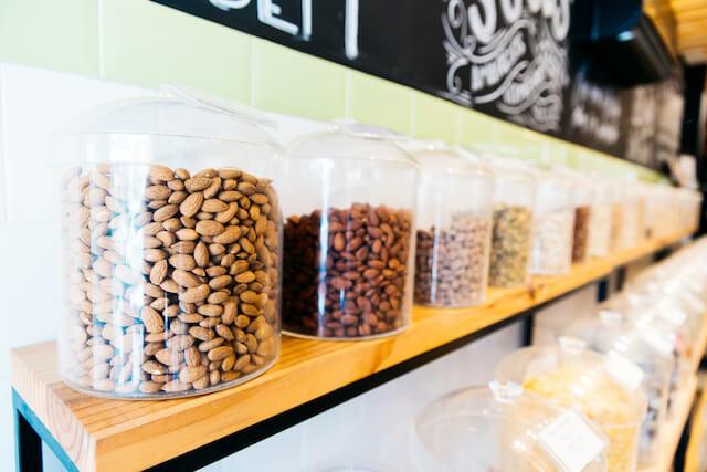Clear jars with nuts neatly organized by color on display shelf