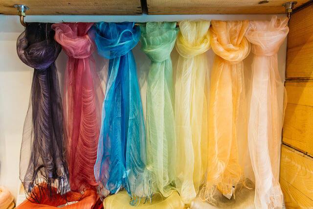 Collection of brightly colored scarves hanging on display