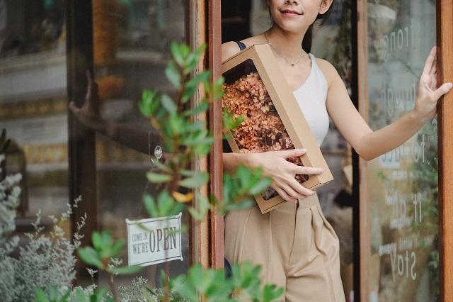 Woman leaving floral shop with box