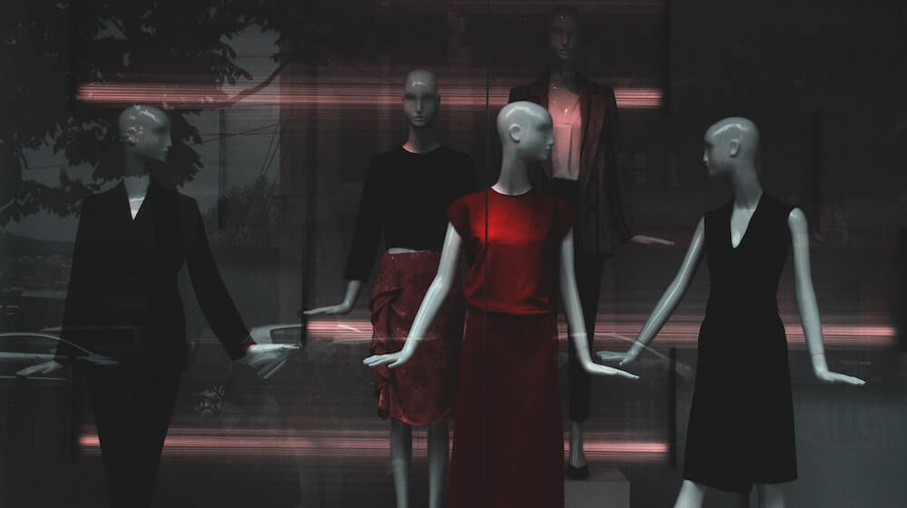 Red dress on display around black dresses