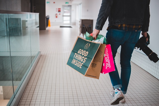 Person carrying shopping bags and camera
