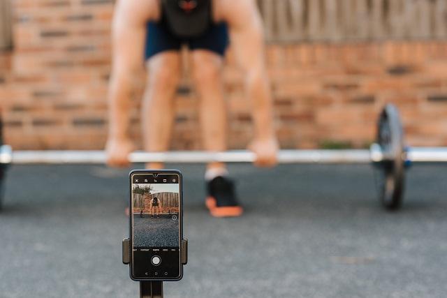 Bodybuilder recording workout