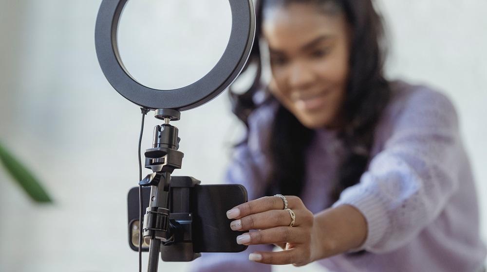 Woman setting up phone on ring light stand