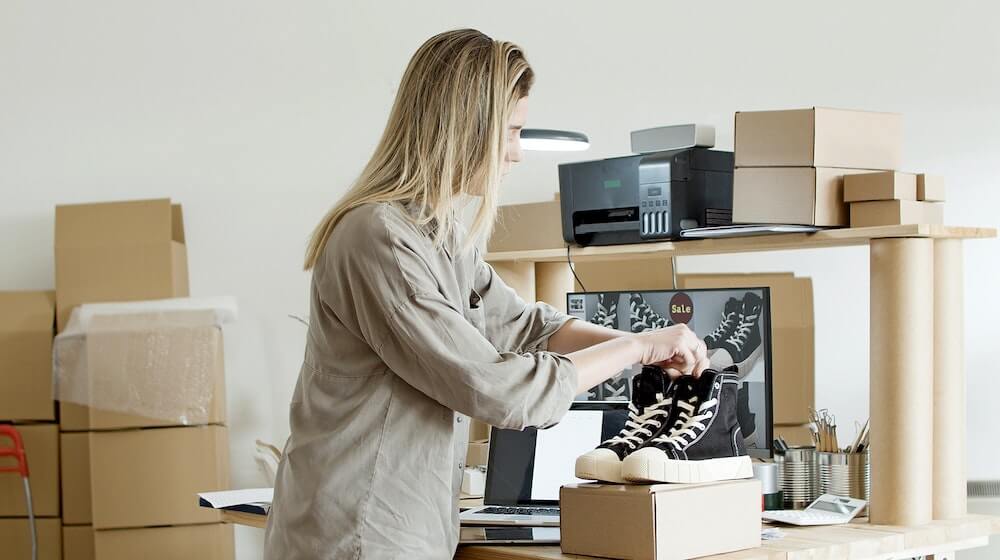 Woman setting up shoes to sell online